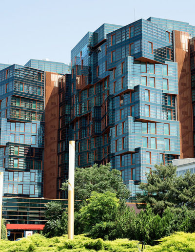 An aerial view of a complex featuring multiple modern buildings with various architectural styles and lush landscaping.