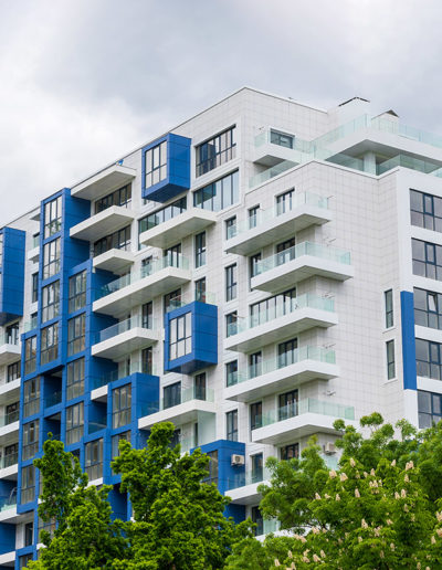 A tall apartment building with a blue and white facade