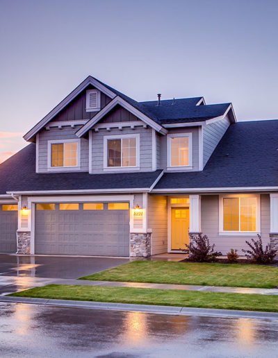 A gray house with a dark roof and a yellow door